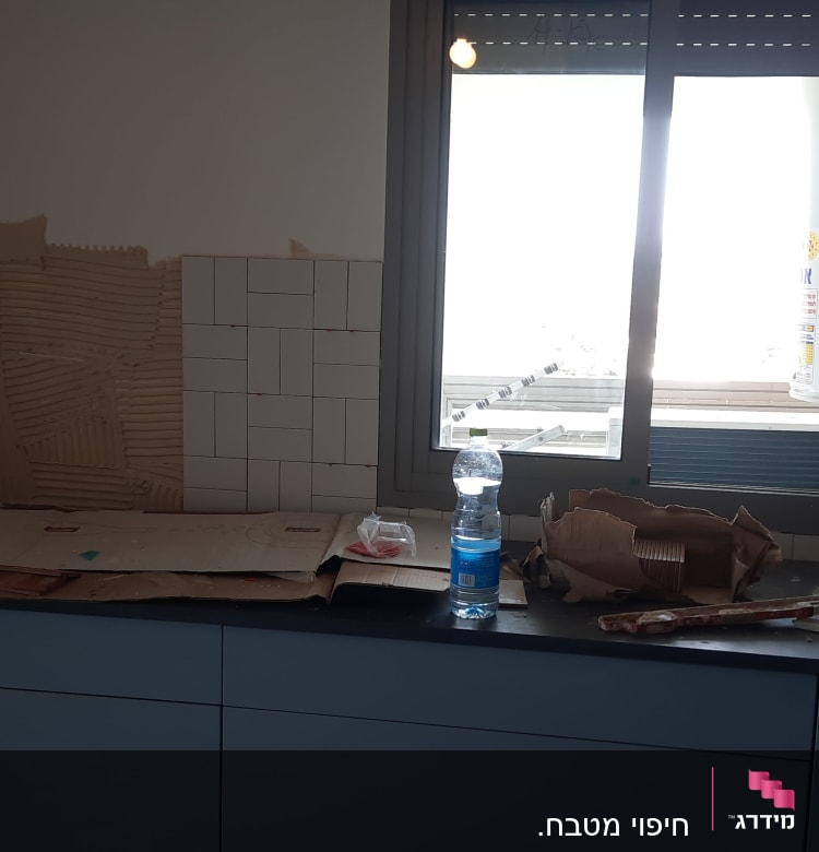 מטבח בשיפוץ עם אריחים וכלי עבודה על השיש